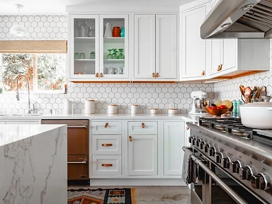 White shaker kitchen with hexagonal tile backsplash, copper dishwasher and leather strap cabinet pulls, designed by Tabinets in Middleborough, MA