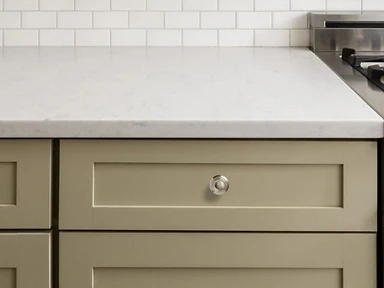 Olive green shaker cabinet drawers with polished nickel knobs and white quartz countertop, installed by Tabinets in Lakeville, MA
