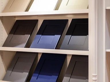 Display of nine cabinet door samples in a 3x3 grid showing various finishes and colors available at the Tabinets showroom